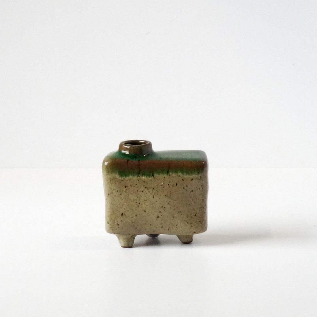 Small rectangular ceramic vase with green top and brown base on a white background