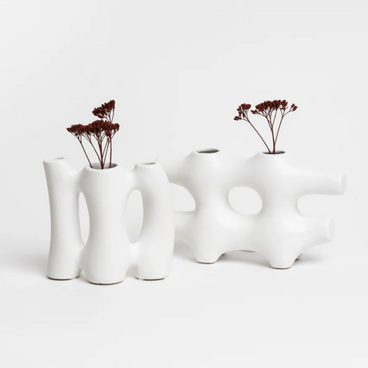 Set of white ceramic vases with unique designs on a light gray background