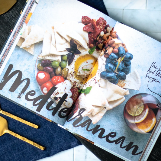 Book page titled 'Mediterranean' with images of food platter on a table