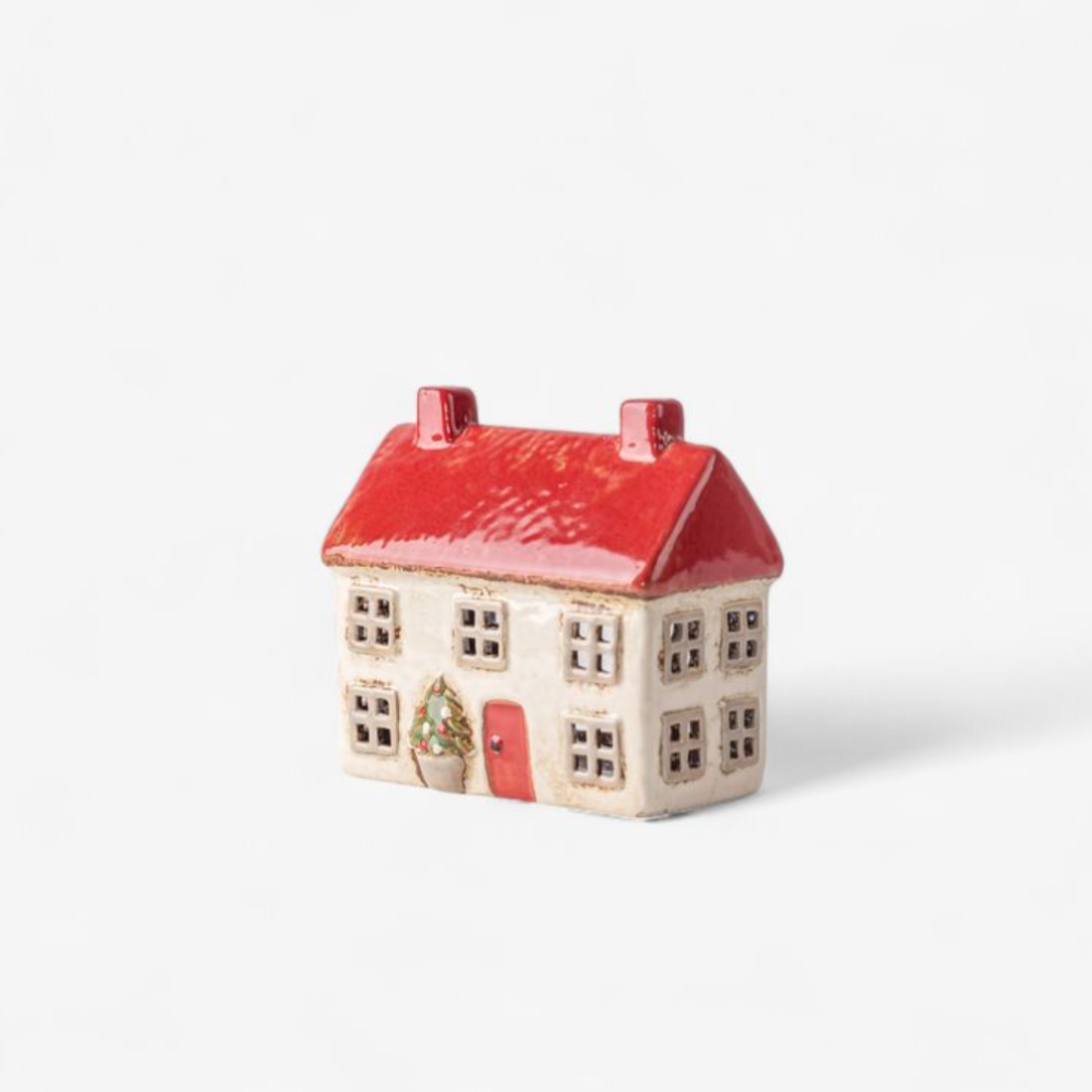 Small ceramic house with a red roof on a white background