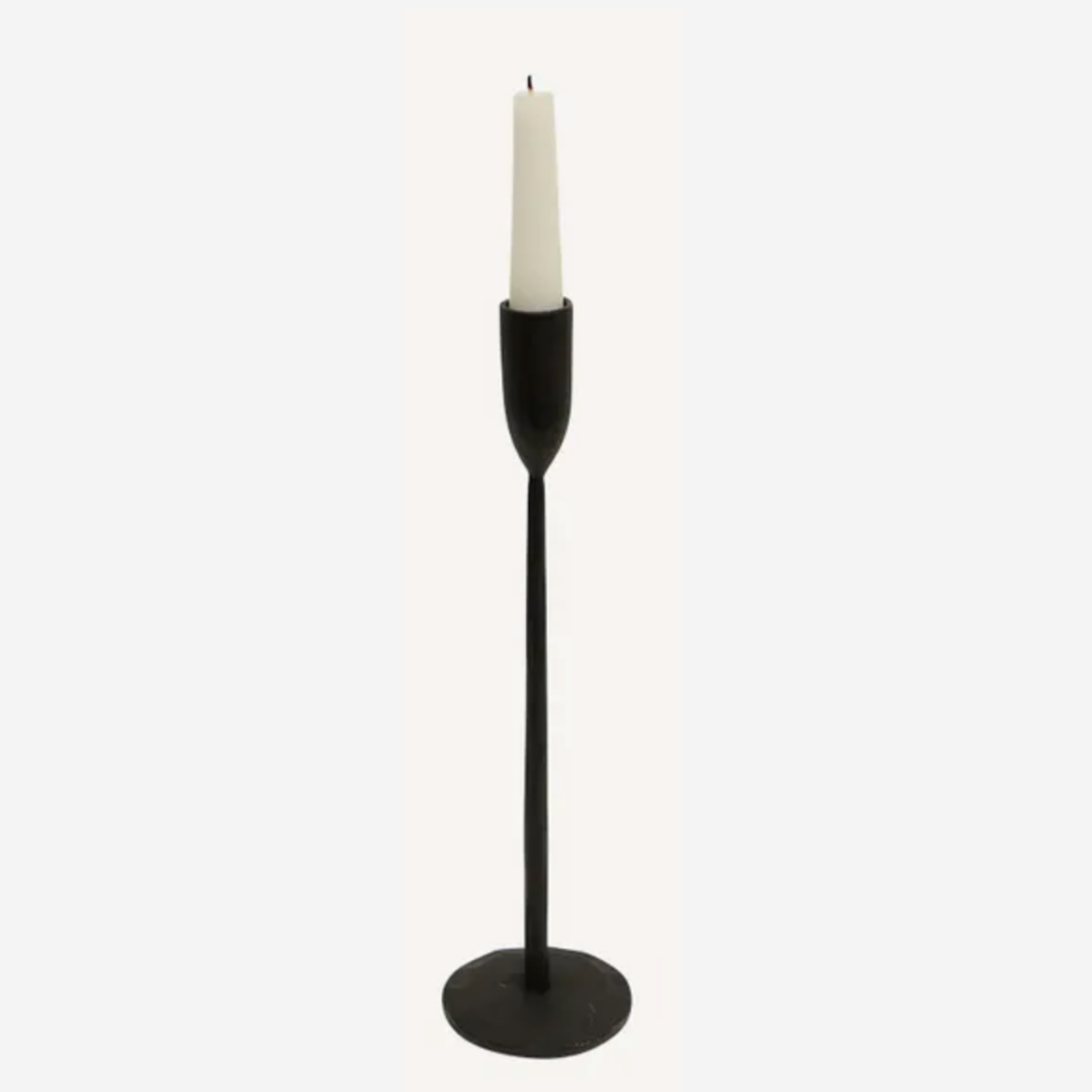 Black candle holder with a white candle on a white background