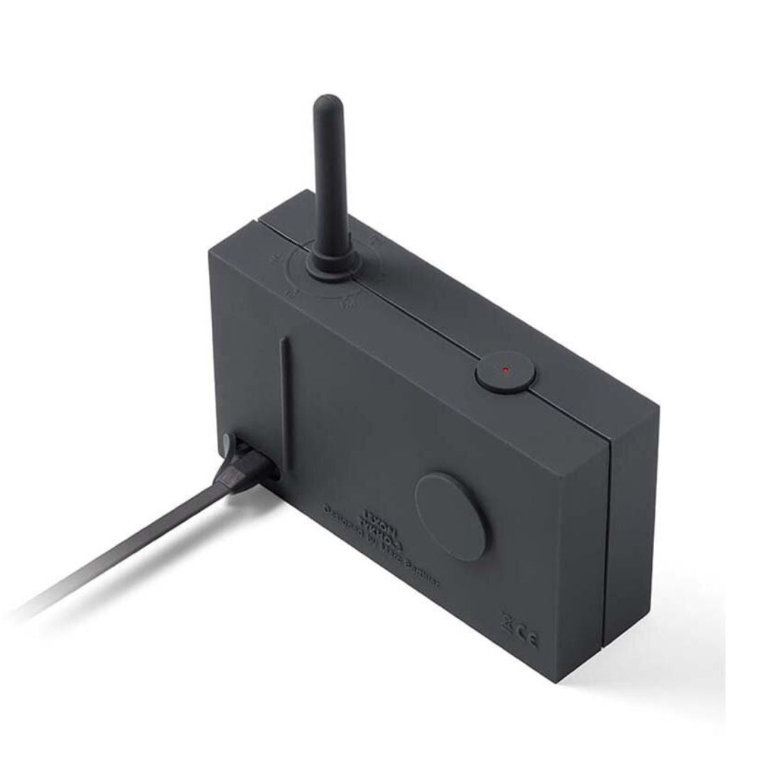 Dark grey radio with antenna and charge cable plugged in on a white background