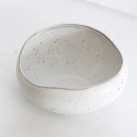 Speckled ceramic bowl on a white surface