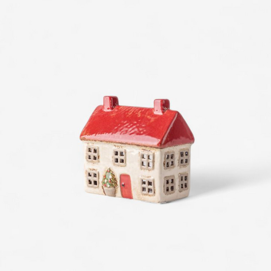 Small ceramic house with a red roof on a white background