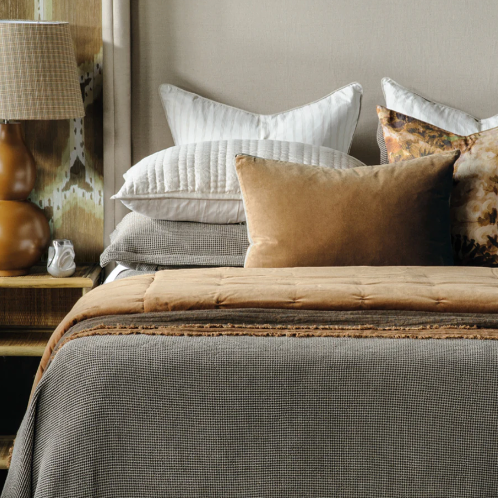 Bedroom with a bed featuring pillows and a textured wall.