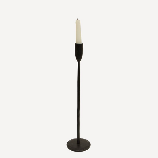 Black candle holder with a white candle on a white background