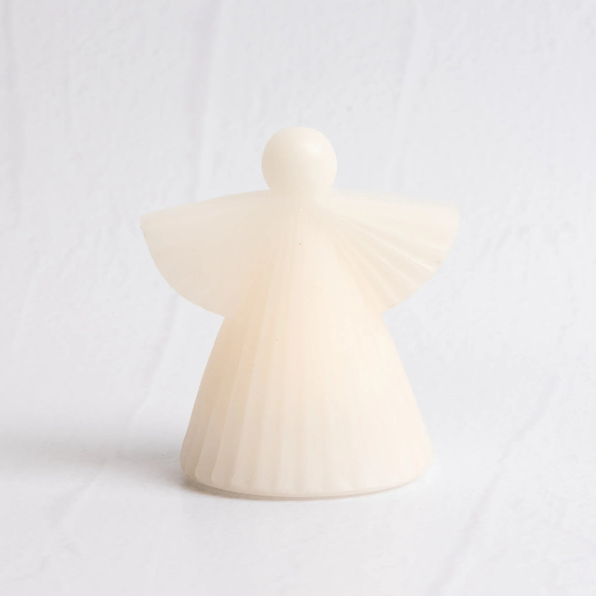 White wax LED angel candle on a light background